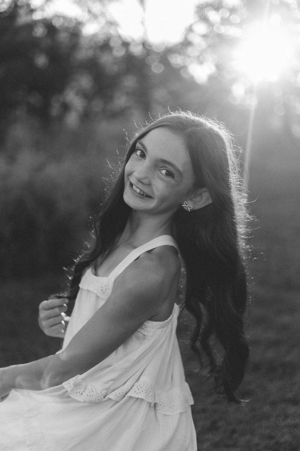 Artistic black and white portraits of a person laughing outdoors with natural backlighting at sunset.