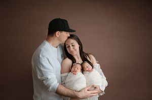 Intimate monochromatic portrait series showing tender family moments with a newborn baby.
