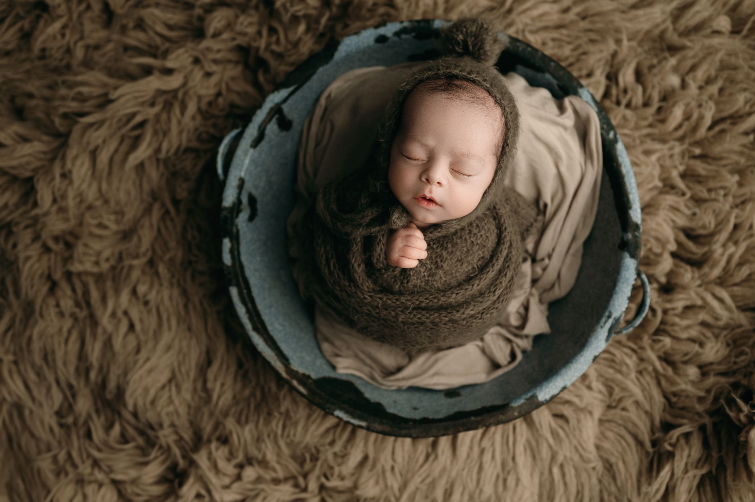 A collage of seven newborn photography images with brown earth-toned backgrounds showing peaceful sleeping positions.