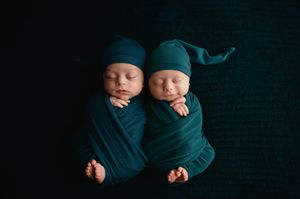 A series of close-up photographs showing a sleeping newborn baby in teal colored wraps against a dark background.