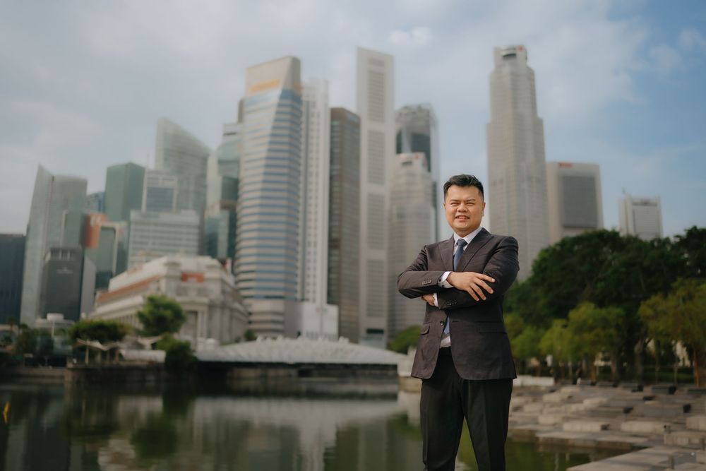 Modern skyscrapers and urban architecture along Singapore's Marina Bay waterfront with a cloudy sky backdrop.