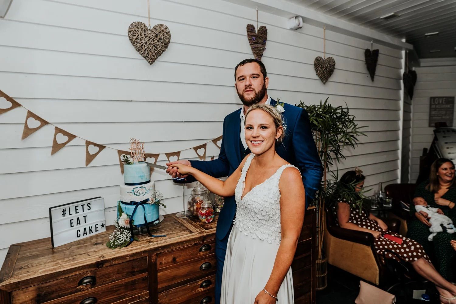 Wedding reception venue decorated with rustic hearts and bunting against white wooden walls.