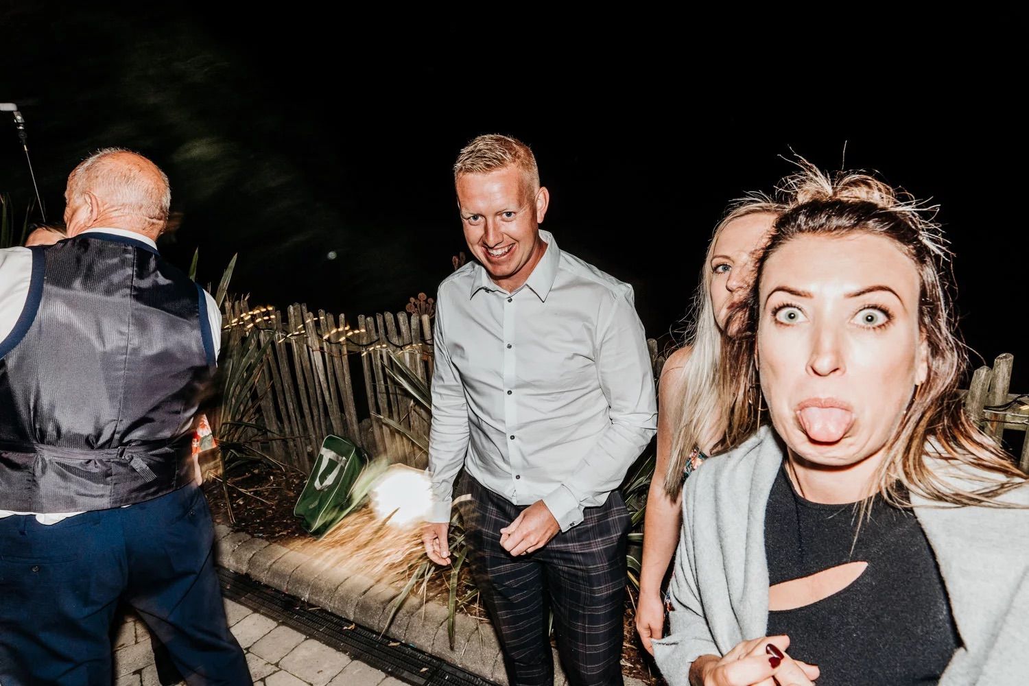 Candid nighttime party photos showing guests dancing and celebrating at a reception.