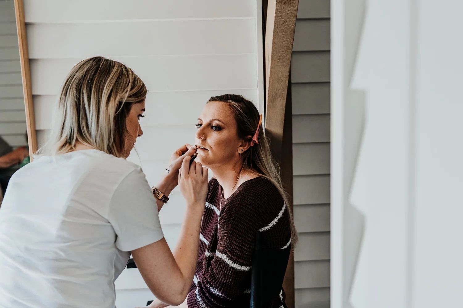 Professional makeup artist applies cosmetics in preparation for an event.