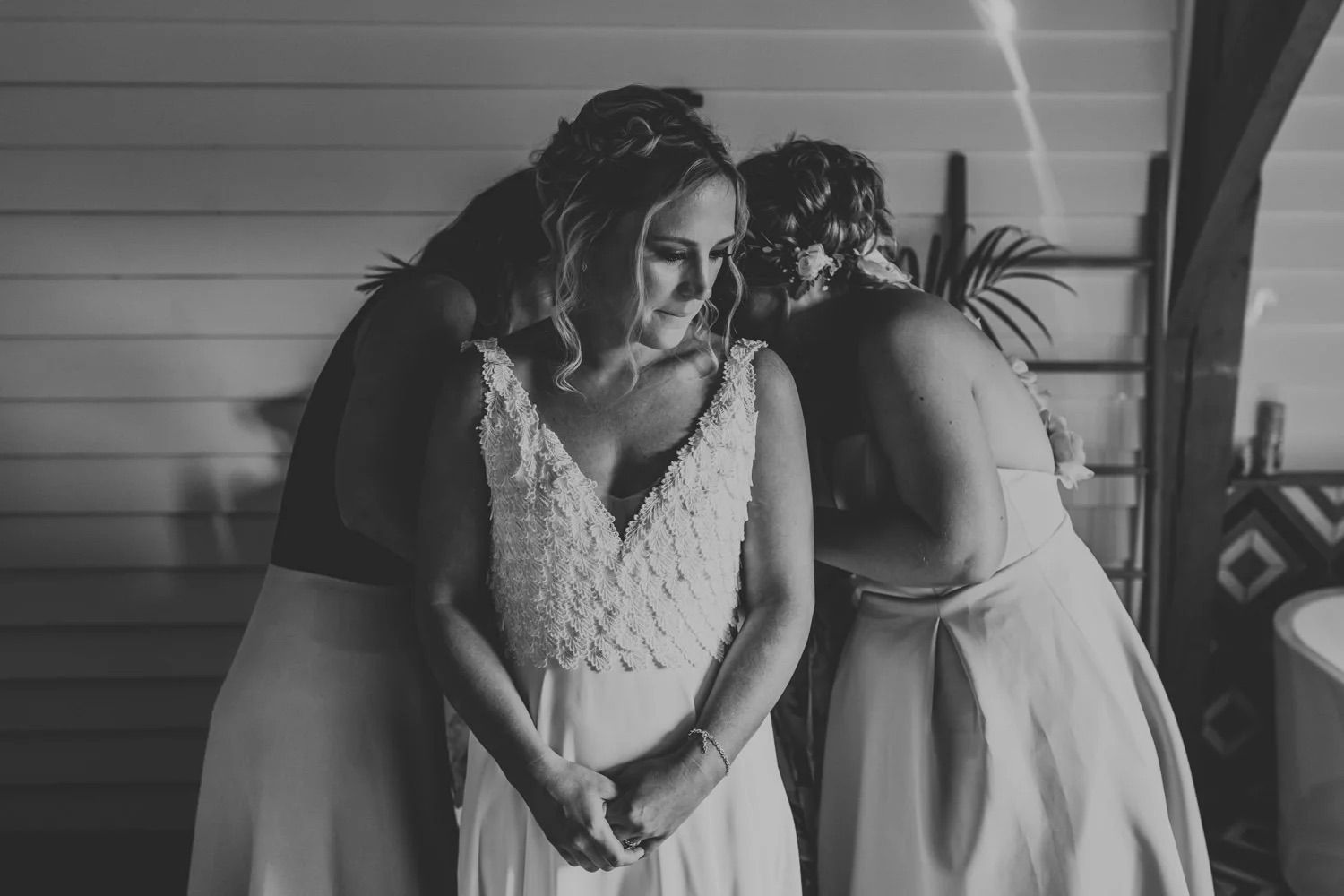 Black and white photo of people mingling at an indoor event with natural window lighting.