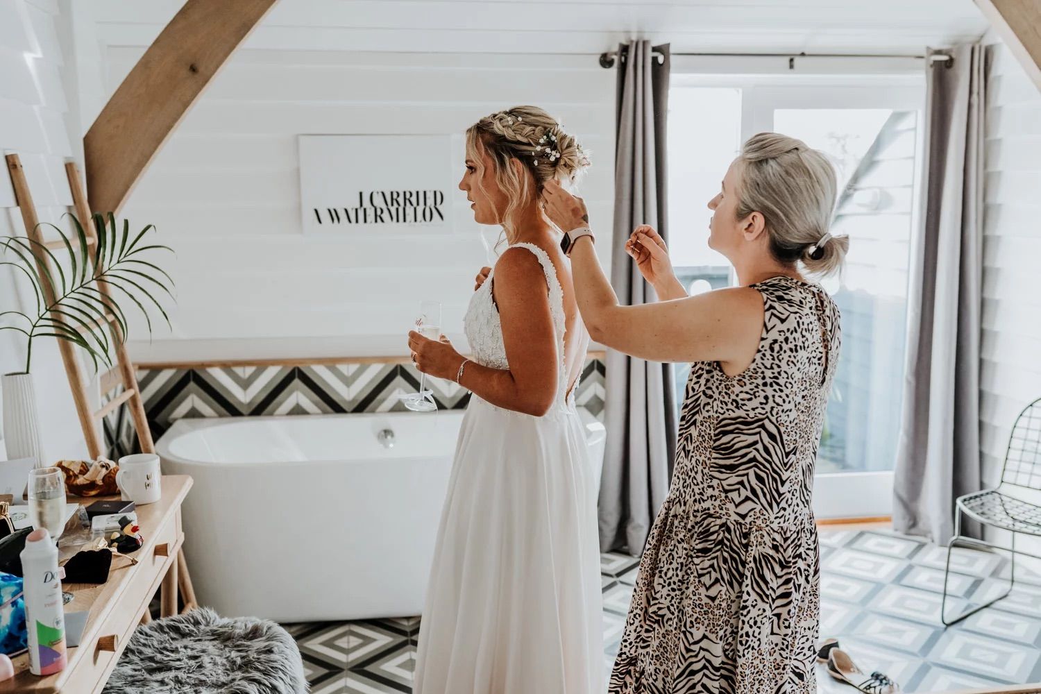 Wedding guests share candid moments and embraces in an indoor venue with natural light.