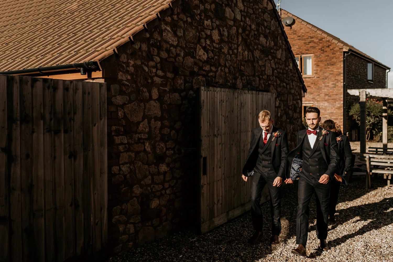 A collection of candid shots showing wedding party members walking outside a rustic brick venue.