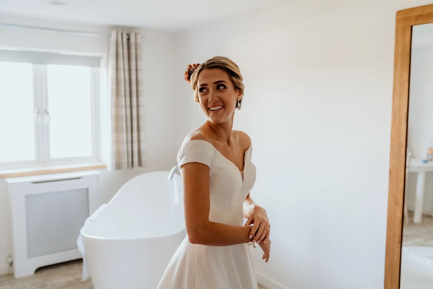 Two images of a bride in a flowing white wedding dress getting ready in a bright, airy room.