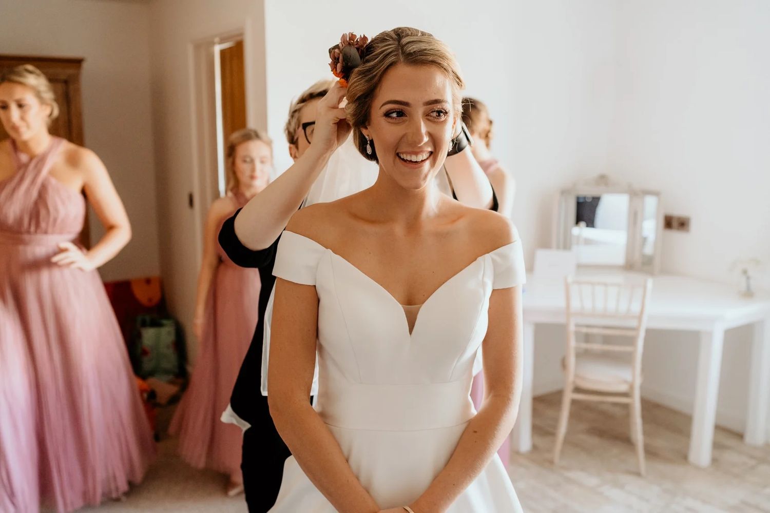 Wedding preparations showing dresses hanging and getting ready moments in a bright sunlit room.