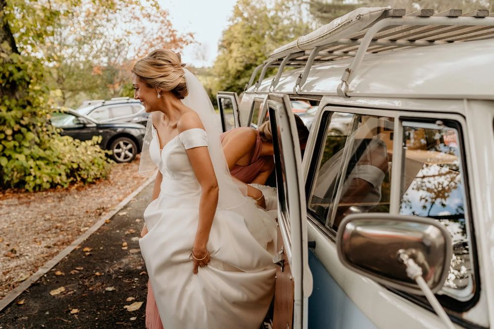 Classic white vintage car decorated for a wedding parked outside with natural surroundings.