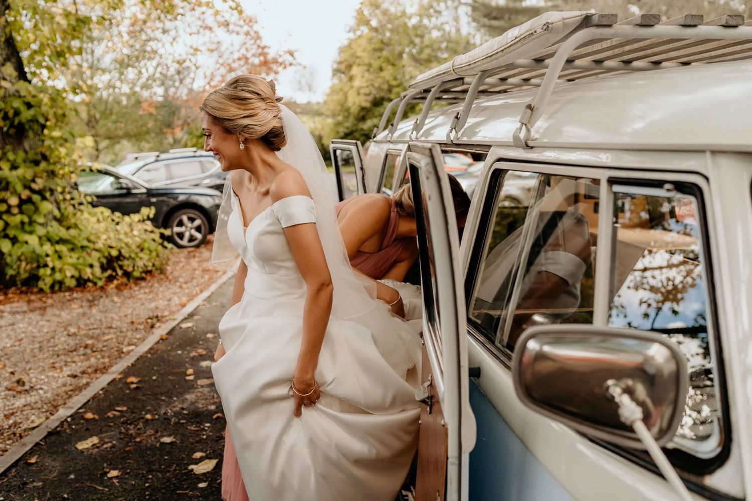 Classic white vintage car decorated for a wedding parked outside with natural surroundings.