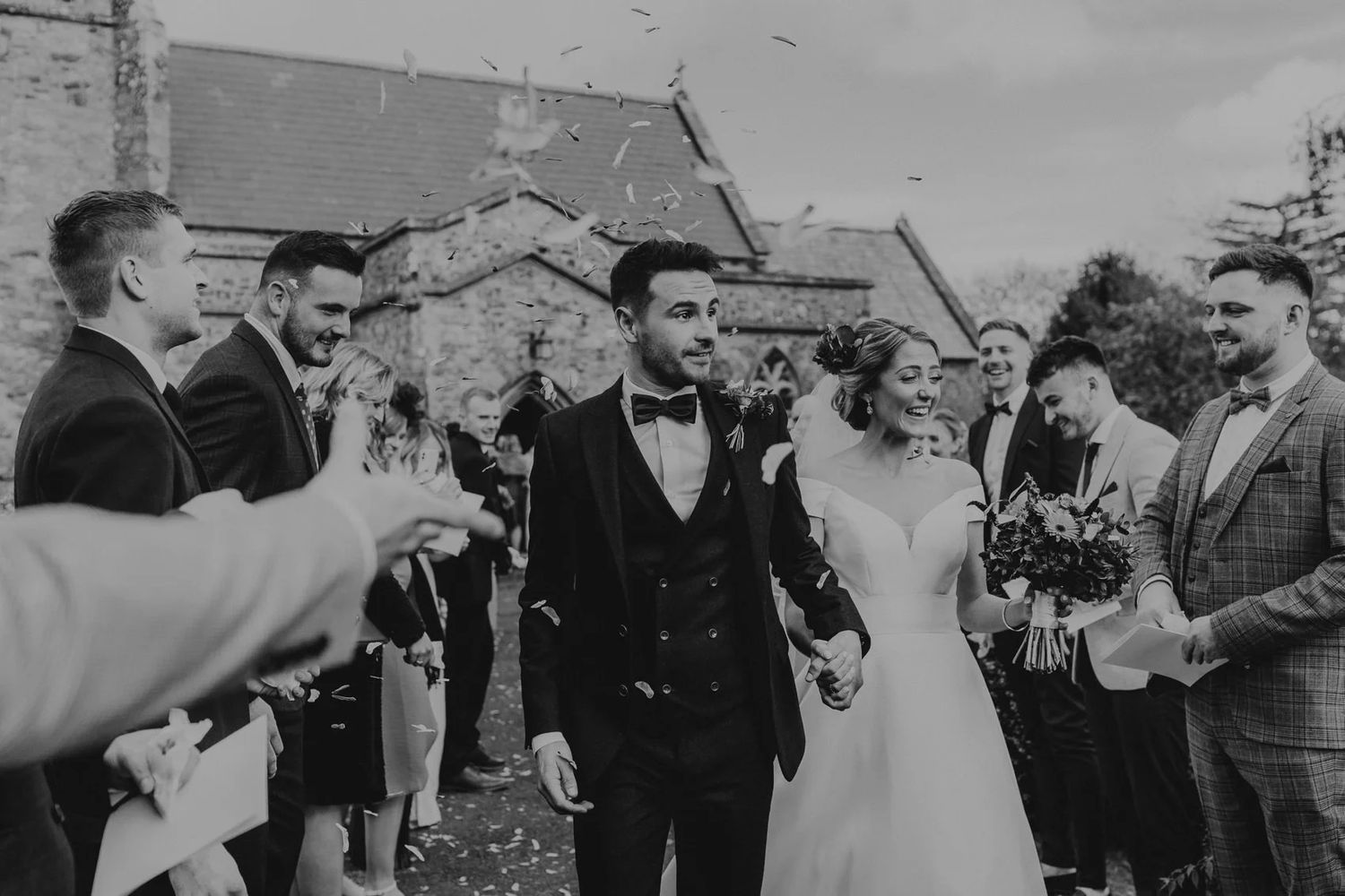 Wedding guests celebrate and raise glasses during an outdoor reception.