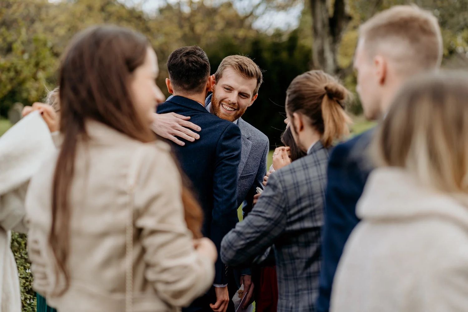 Wedding guests mingle and socialize during outdoor celebration.