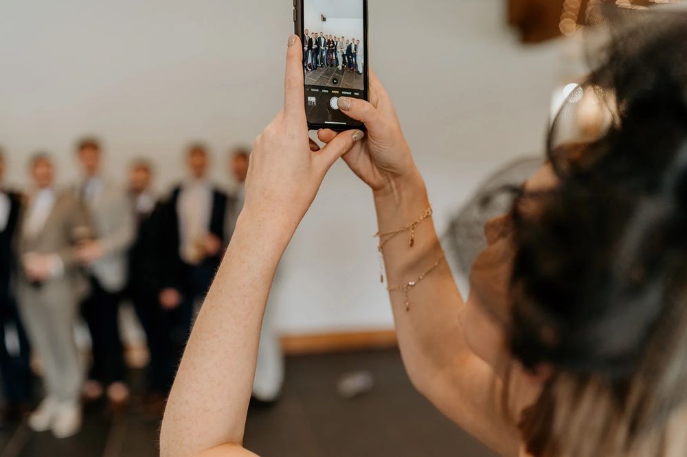 Wedding guests capture special moments on their phones during a ceremony.