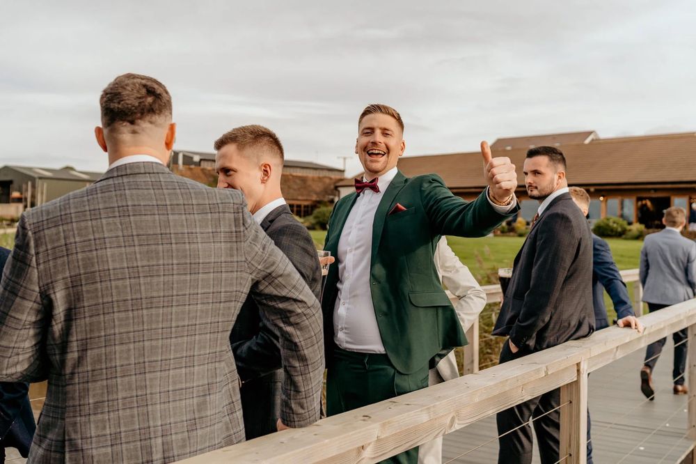 Groomsmen share laughs during outdoor wedding celebrations.