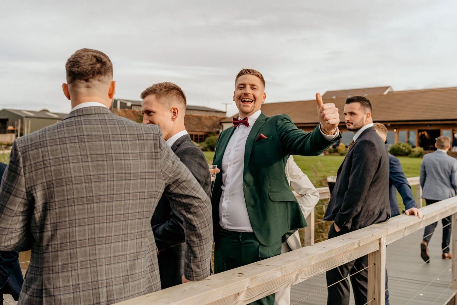 Groomsmen share laughs during outdoor wedding celebrations.