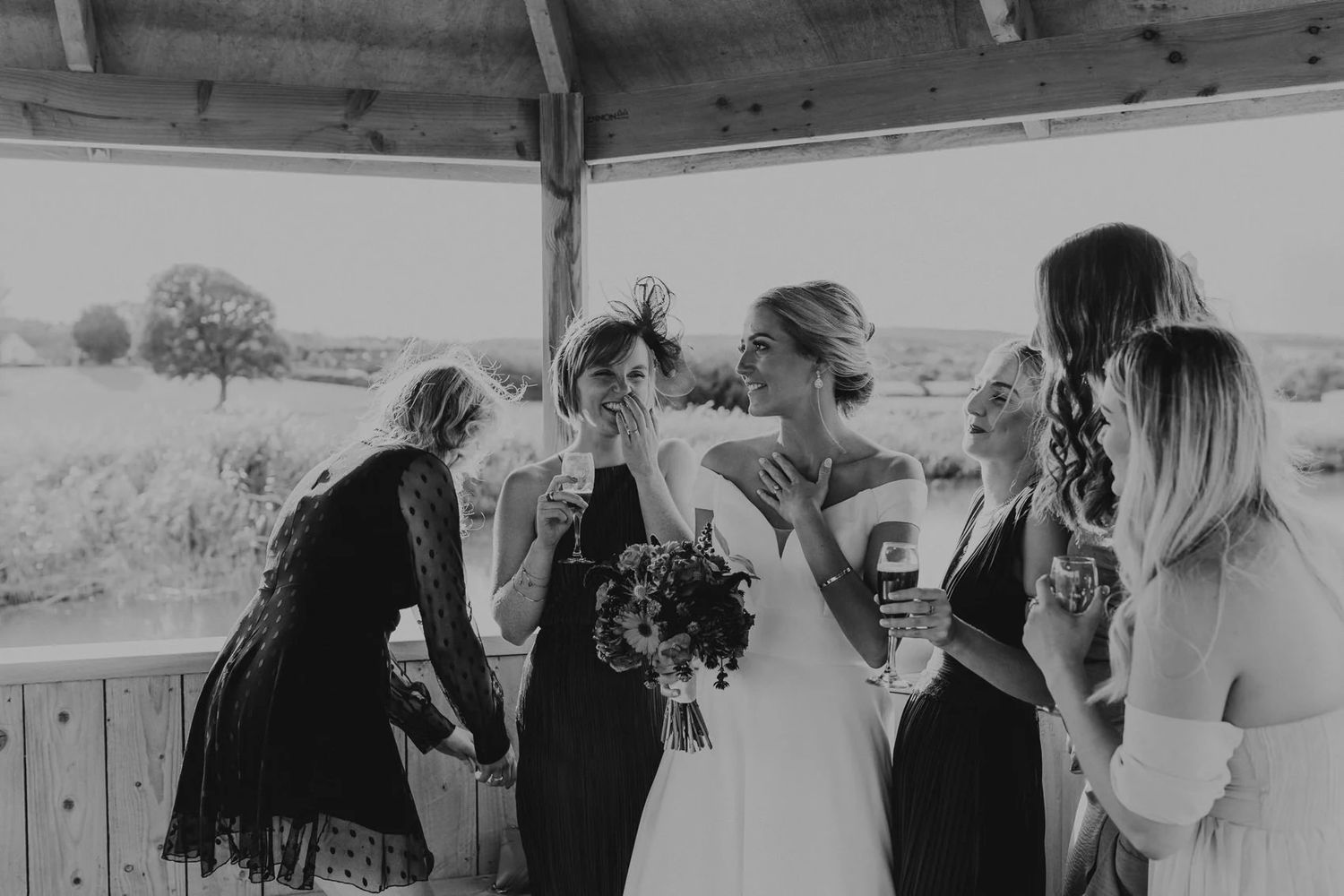 Wedding celebration captured under rustic wooden pavilion with guests in attendance.