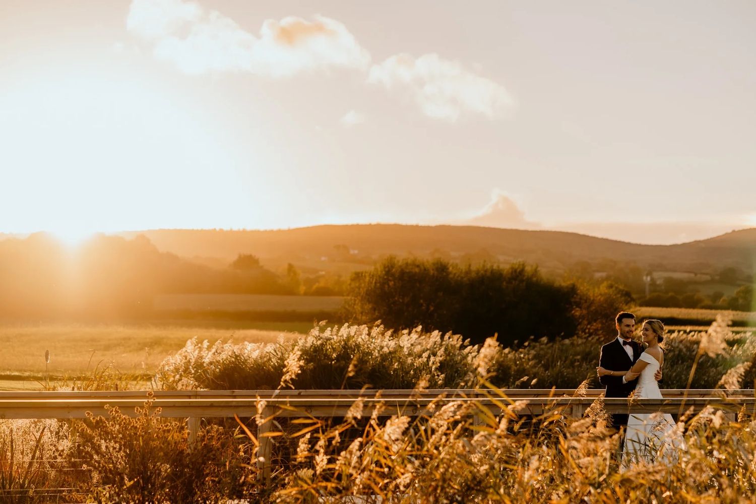 Panoramic sunset view of rolling hills and countryside during an outdoor wedding celebration.