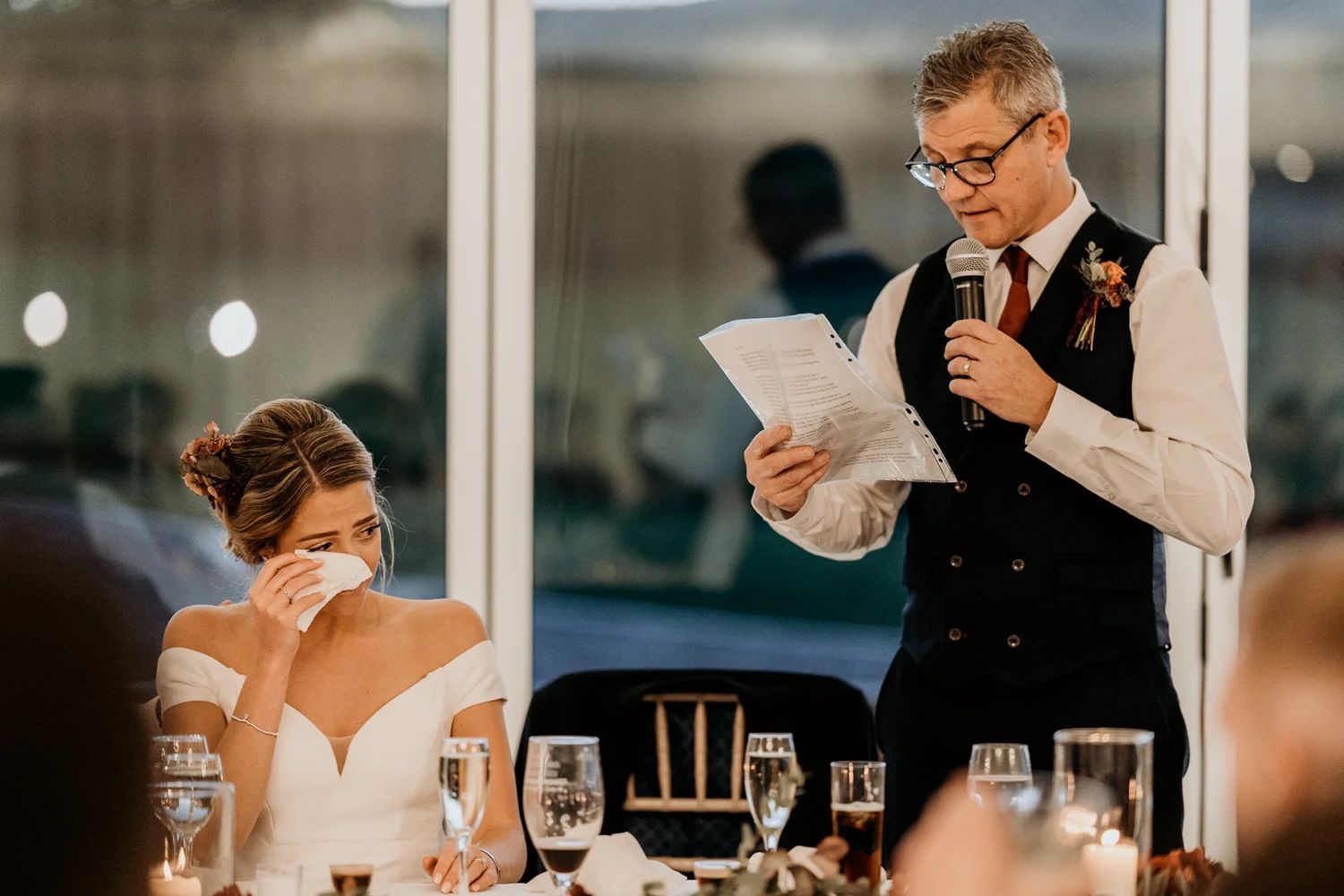 A romantic moment between a couple during their wedding reception dinner at an elegant indoor venue.