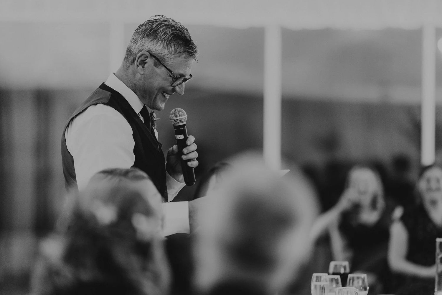 Black and white candid moment captured during wedding reception celebrations.