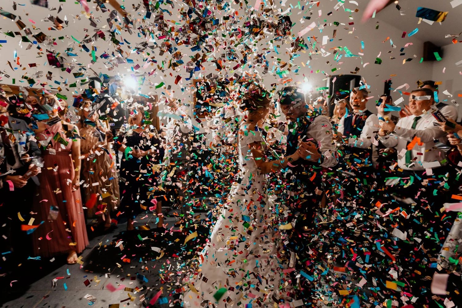 Colorful confetti showers down during a lively reception celebration.
