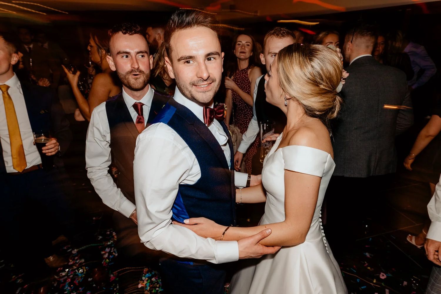 Lively dance floor scene at wedding reception with guests enjoying the celebration.
