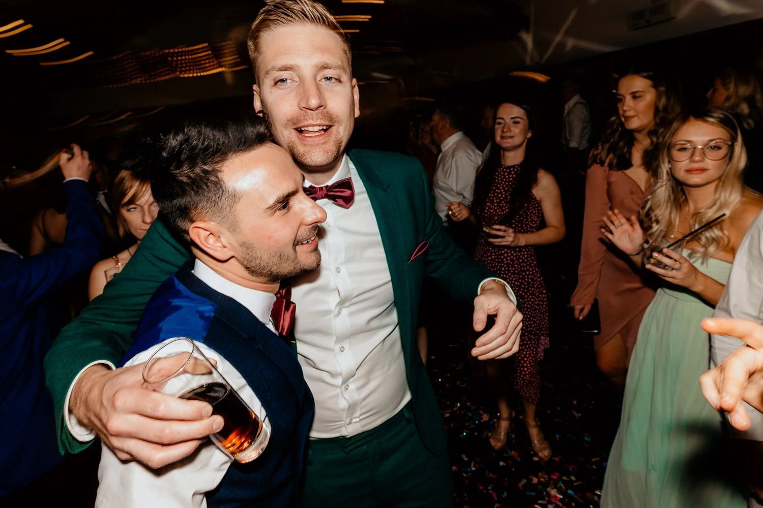 People dancing and enjoying themselves at an energetic wedding reception.