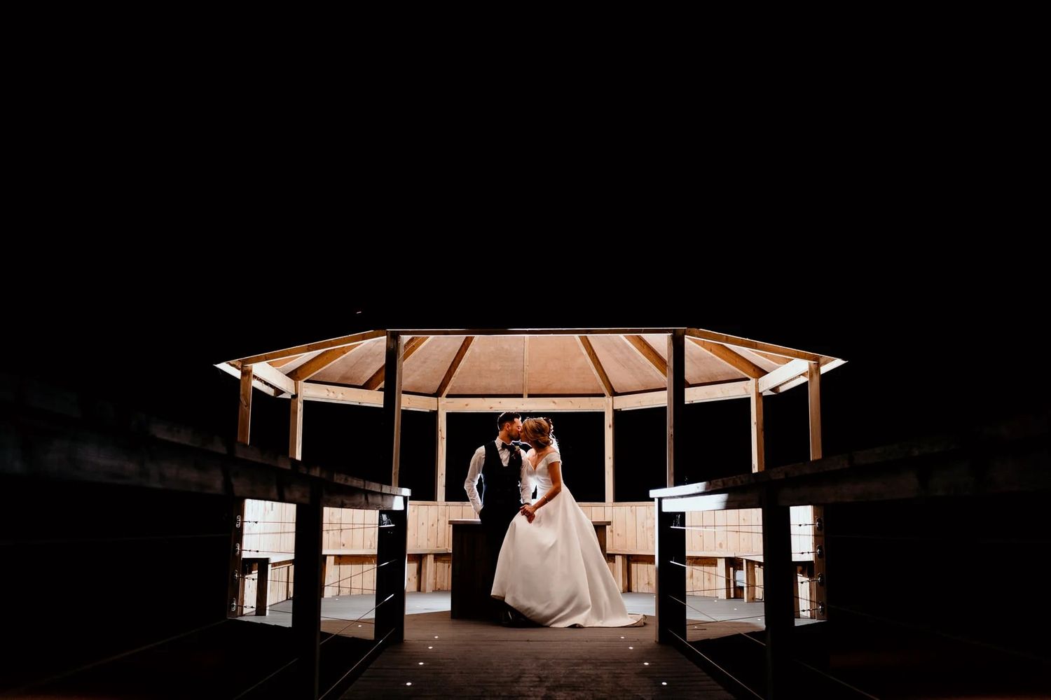 Minimalist wedding reception venue with dramatic lighting and architectural elements.