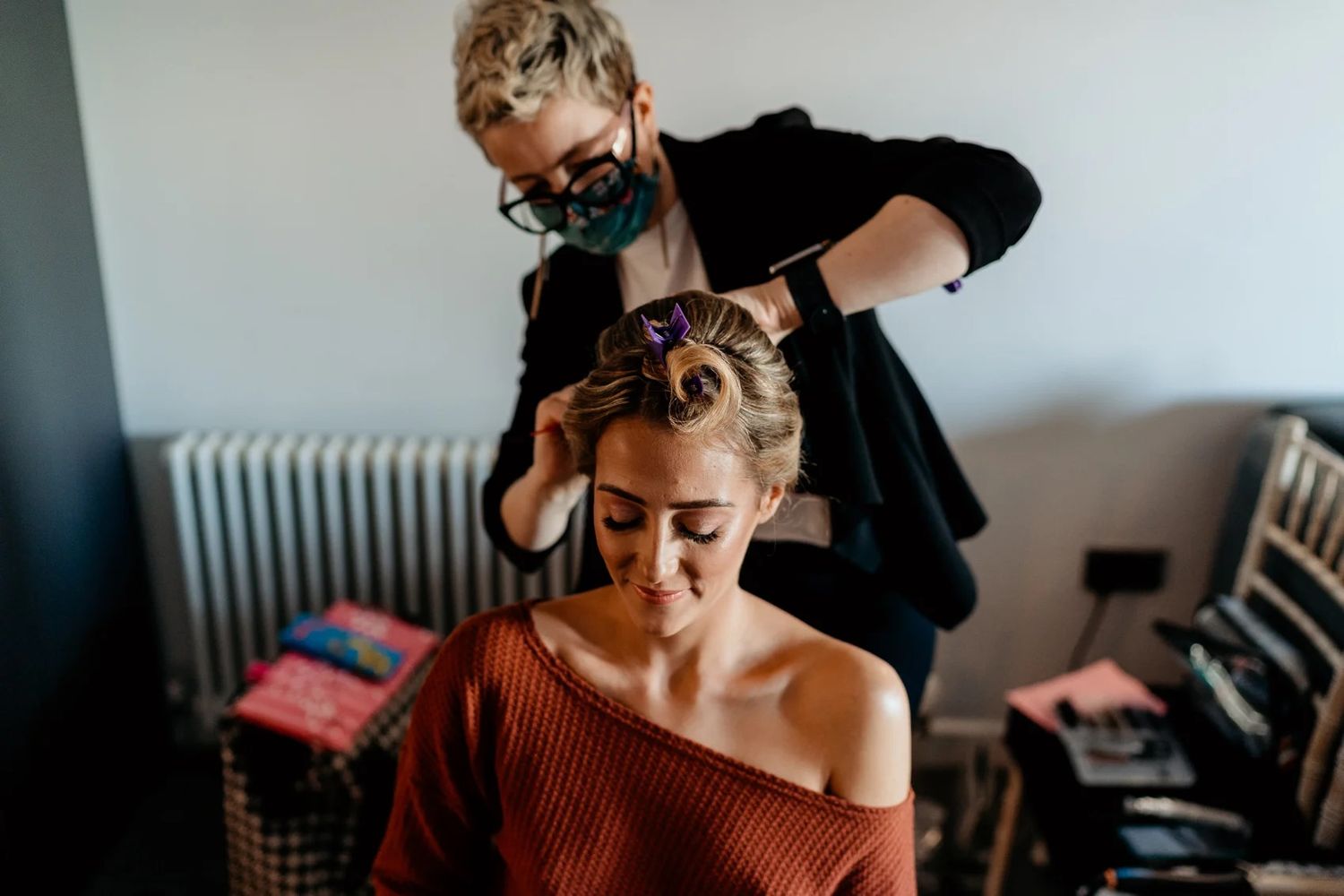 Wedding photographer captures candid getting ready moments in rustic interior setting.