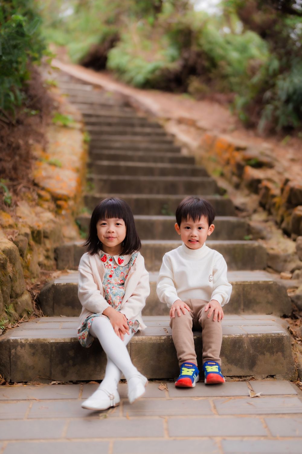 Siblings siting on stone steps near Shilin District Taipei hiking trail