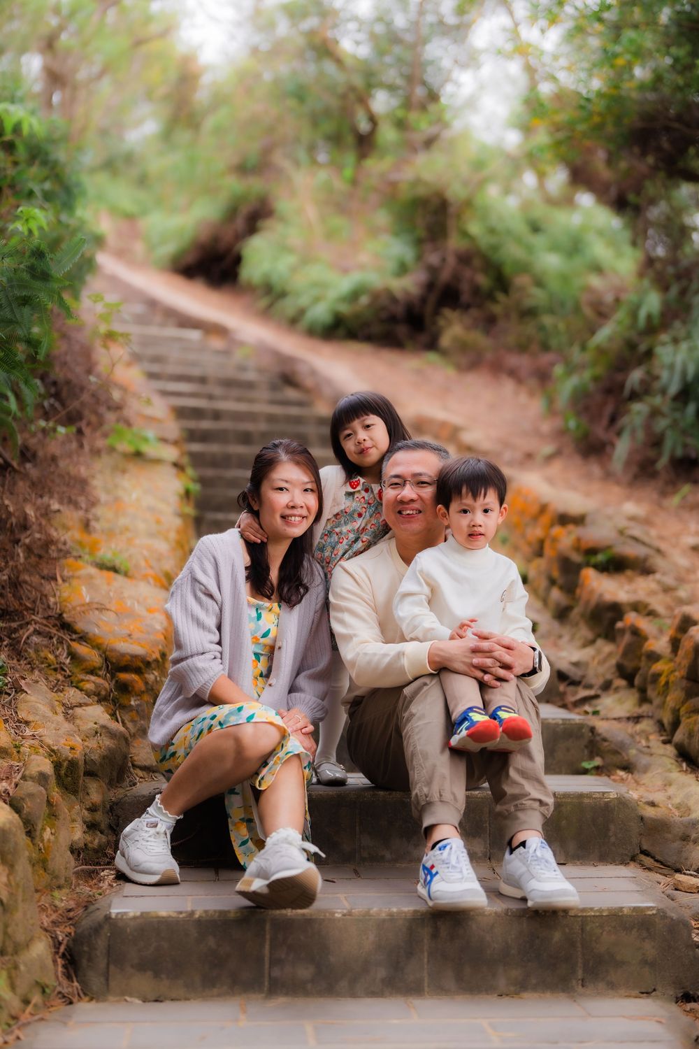 A family sits together on stone steps along on Battleship Rock Trail Taipei
