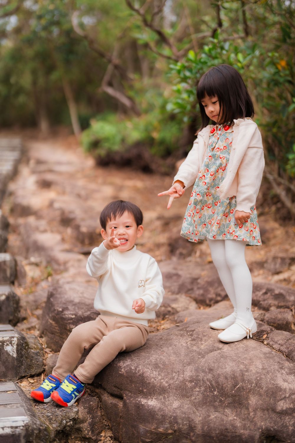 Two kids playing on rock near Junjianyan hiking trail in Shilin District Taipei