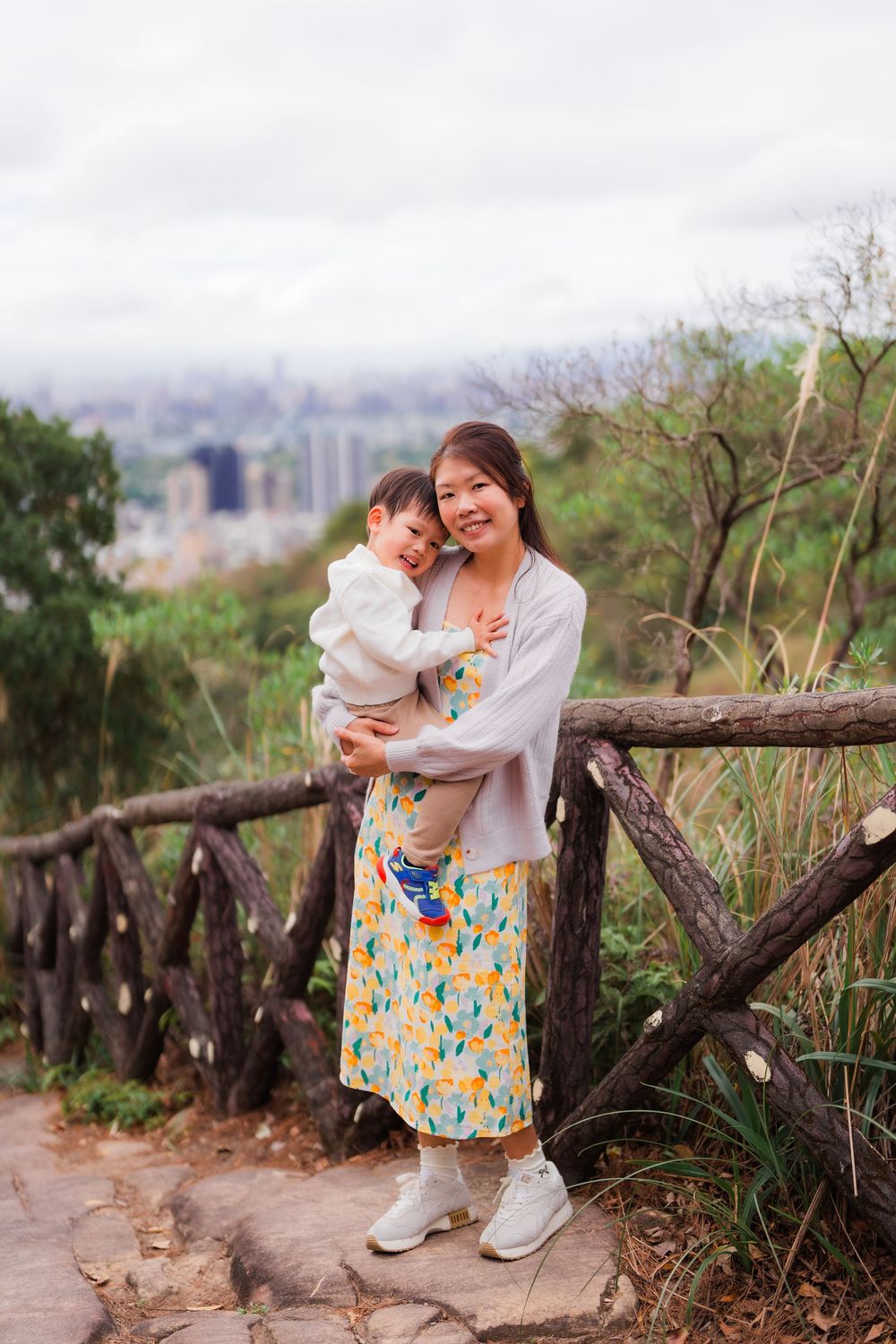 Cute moment of mom and son with from Battleship Rock with Taipei city scenery in the background.
