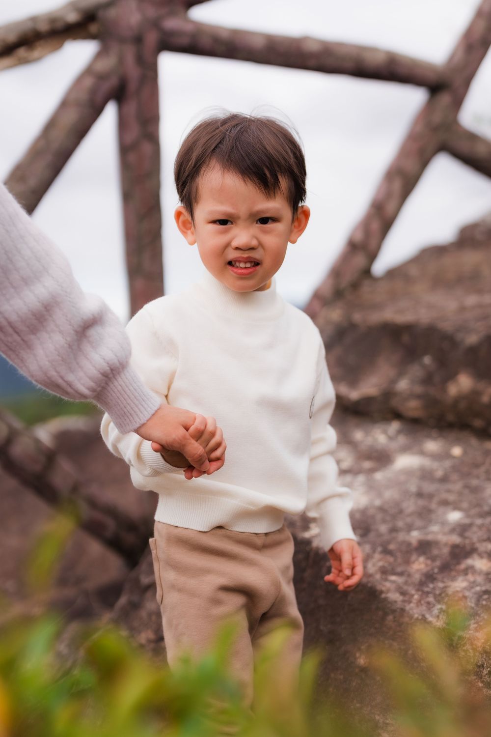 A young boy holding his father's hand along Battleship Rock hiking trail in Taipei Taiwan