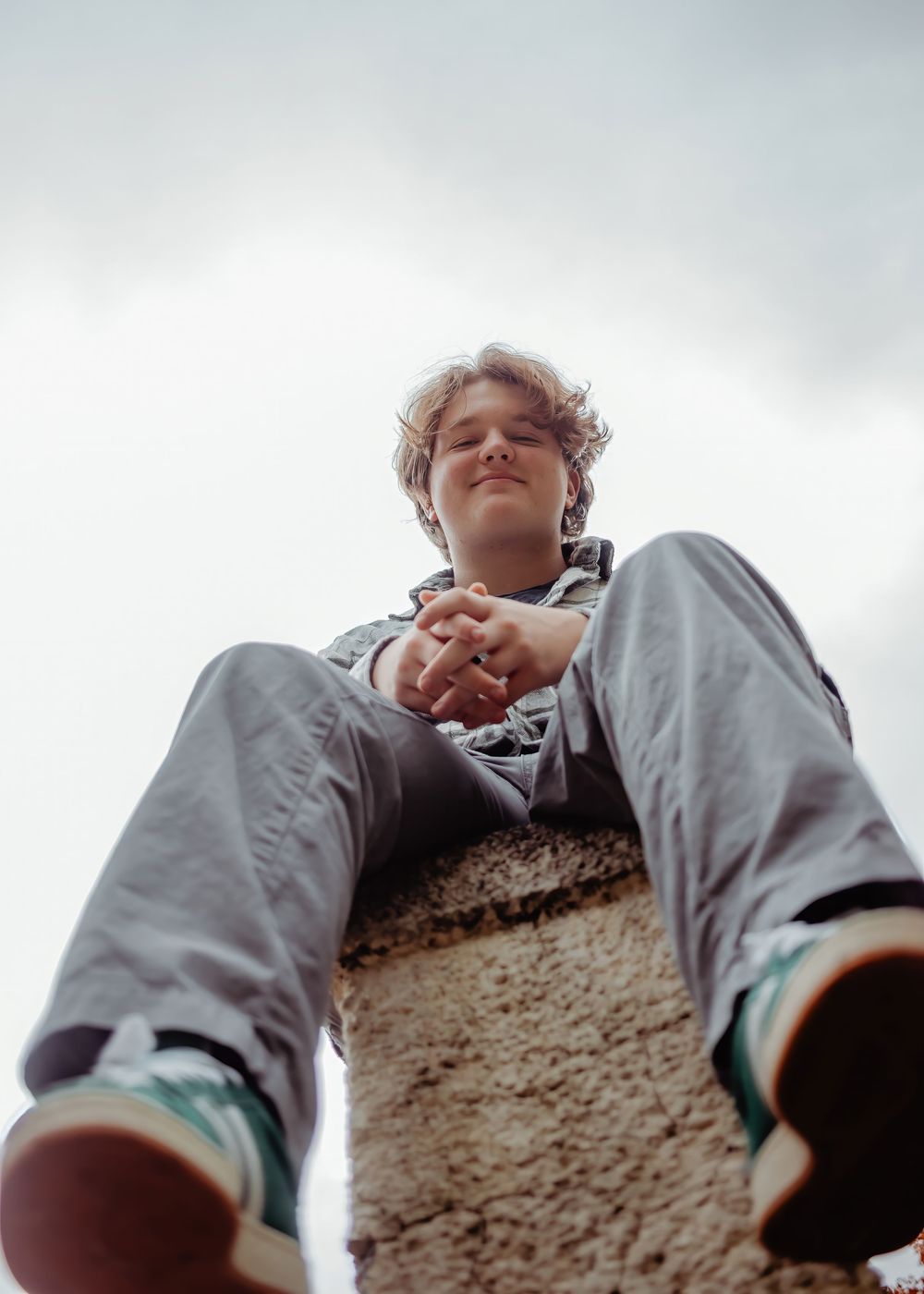 A montage of four low-angle views showing someone in a gray sweatshirt looking down at the camera.