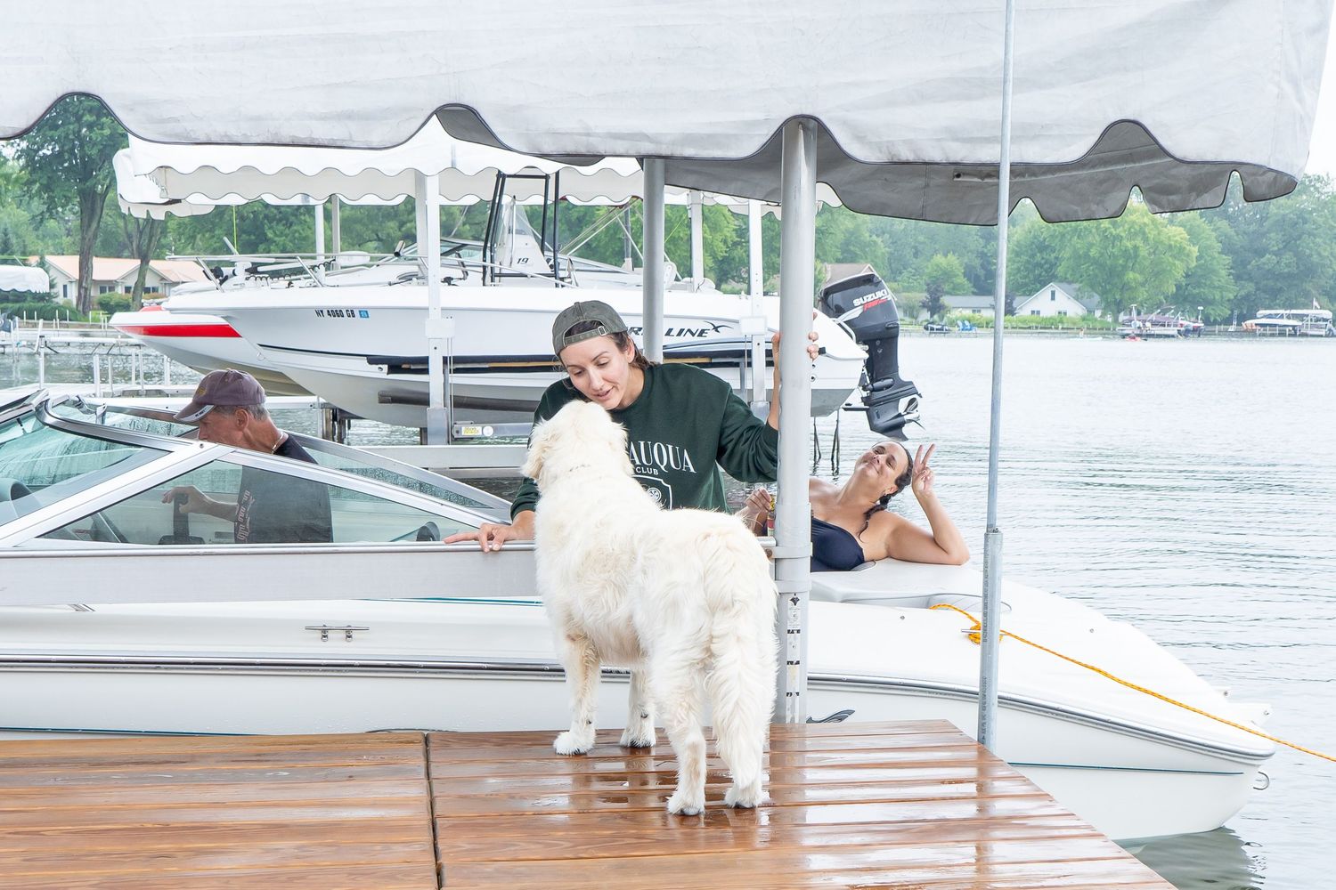 multiple boats moored at a marina with white canopies and cloudy skies in New York.