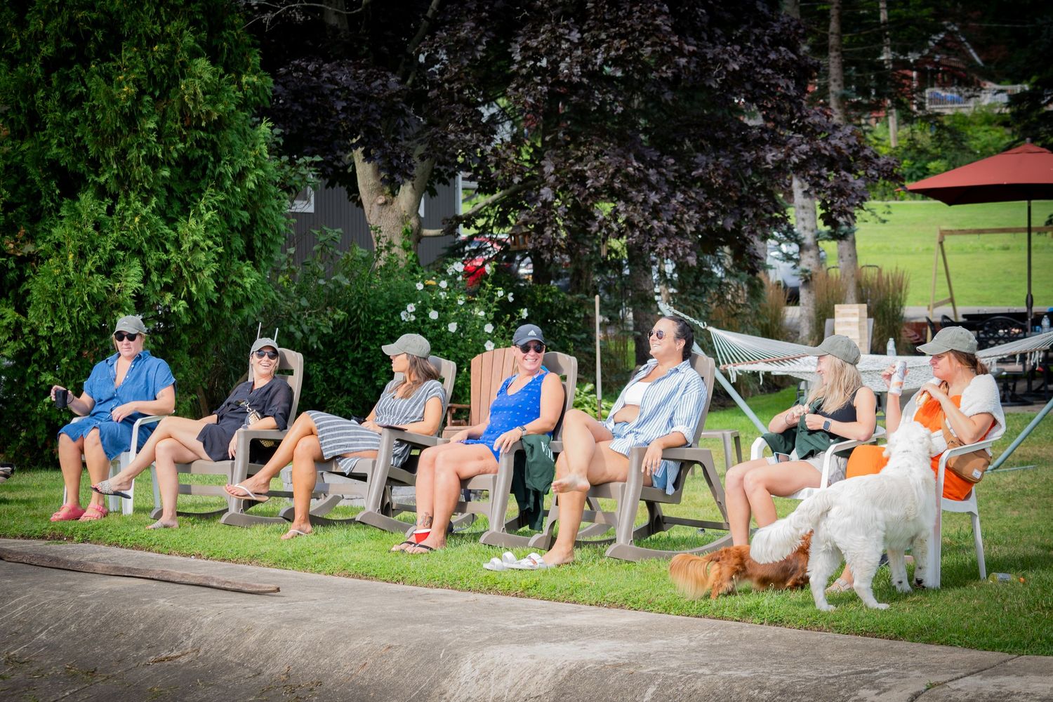 A group of people relaxing in lawn chairs while enjoying an outdoor gathering at a bachelorette party on a sunny day.