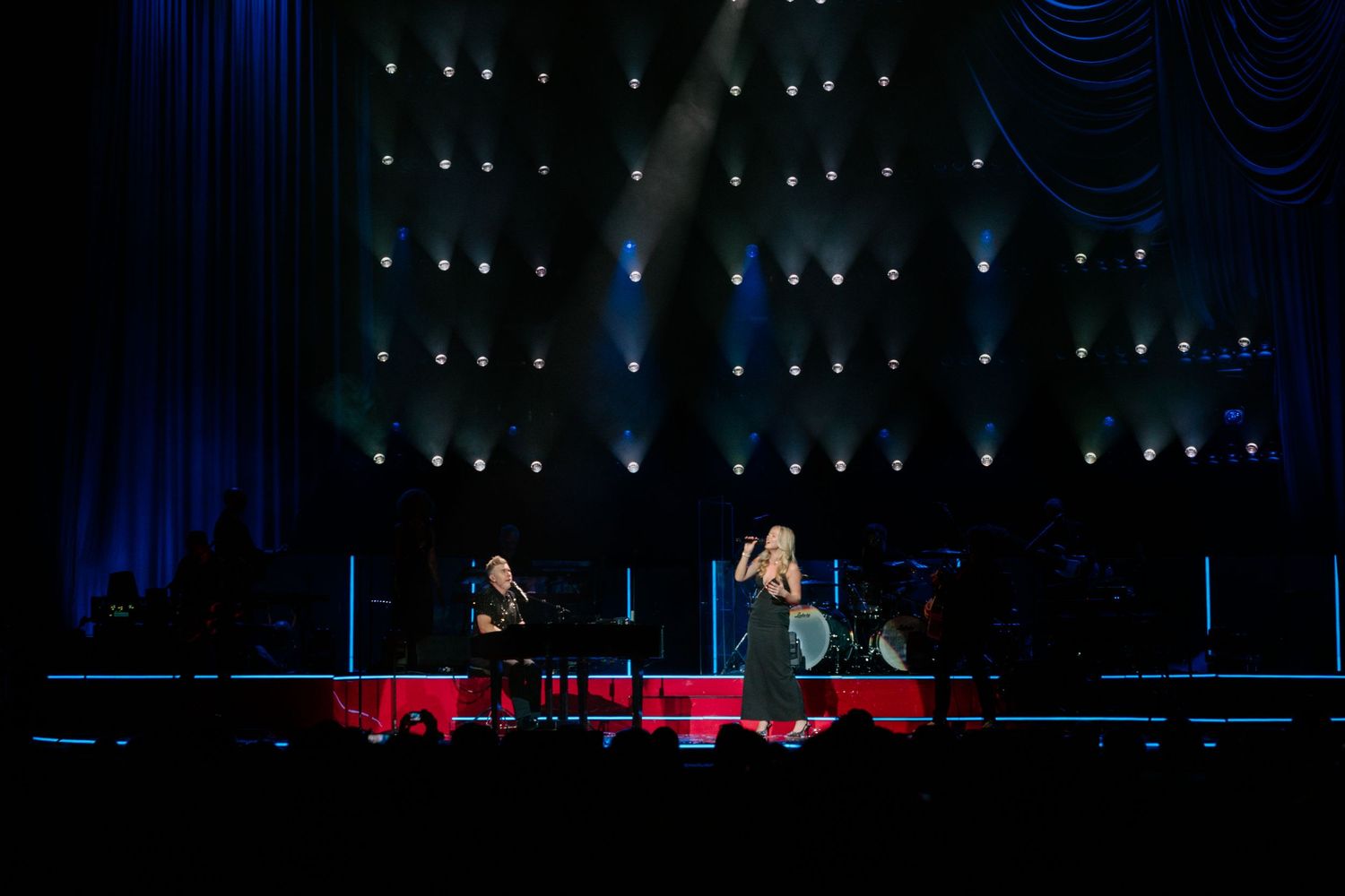 Dark stage illuminated with blue lights and spotlights during a live performance setup.