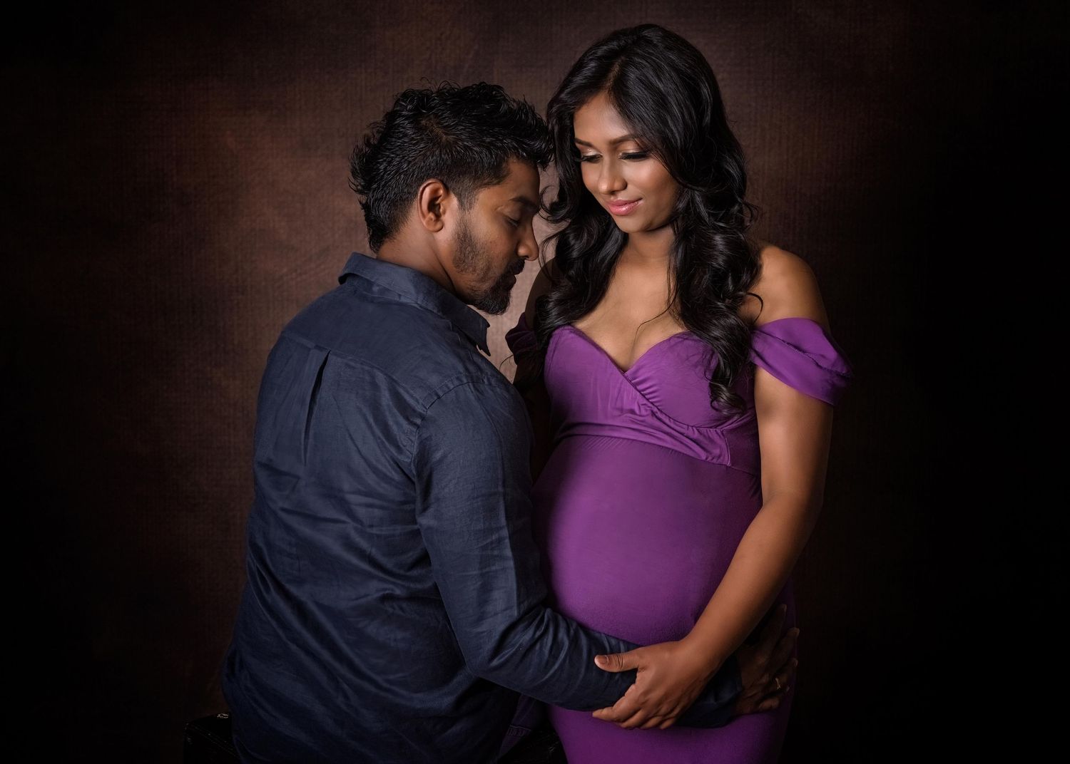 Ethereal maternity portrait featuring a person in a flowing beige dress with puffy sleeves and a delicate star crown headpiece.