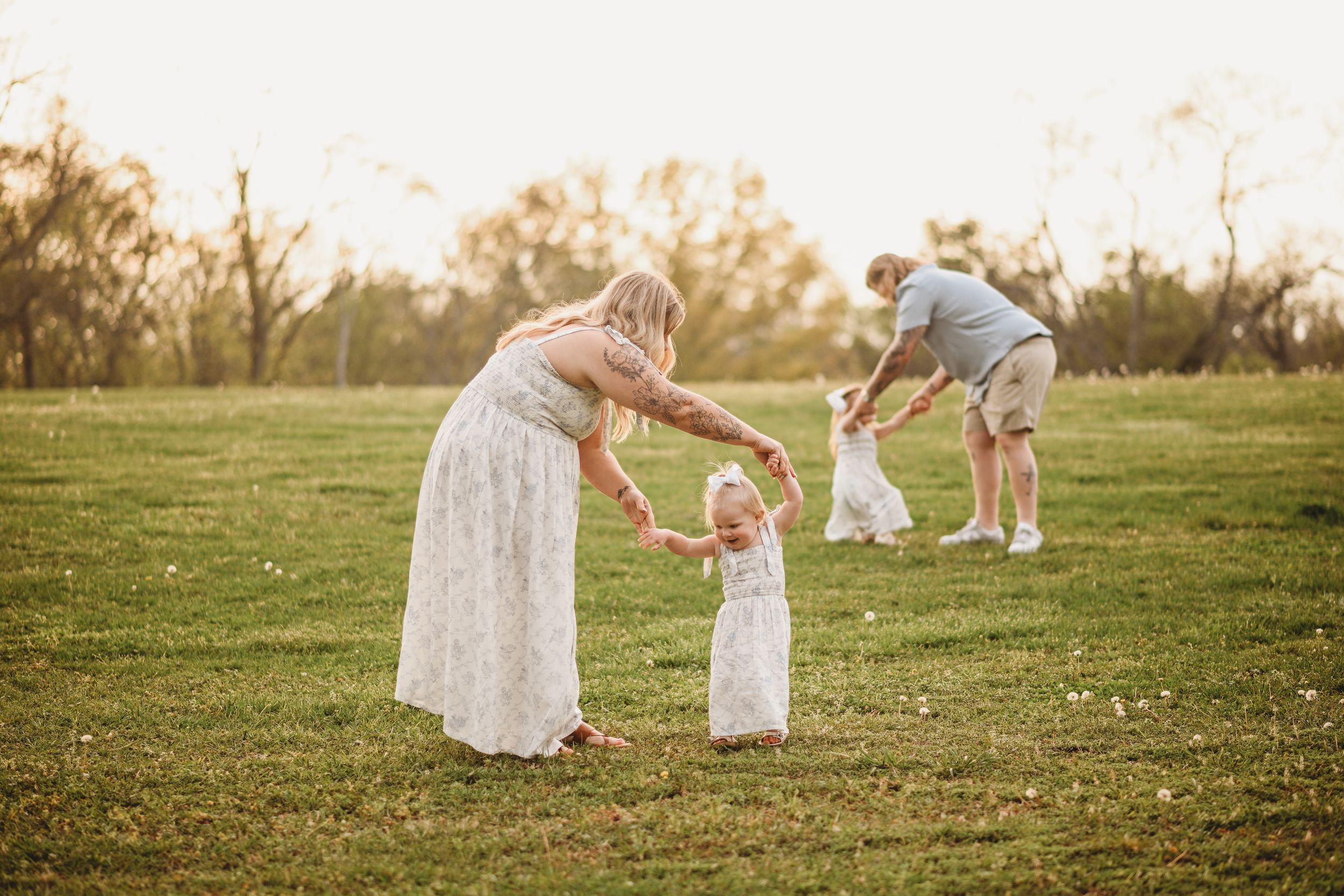 Family sitting together on grassy field during sunset photoshoot.