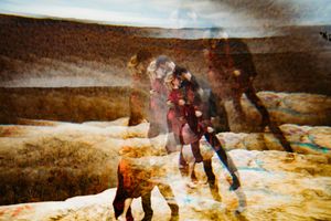 Abstract multiple exposure artistic photo of couple walking on rocky terrain with warm autumn earth tones.