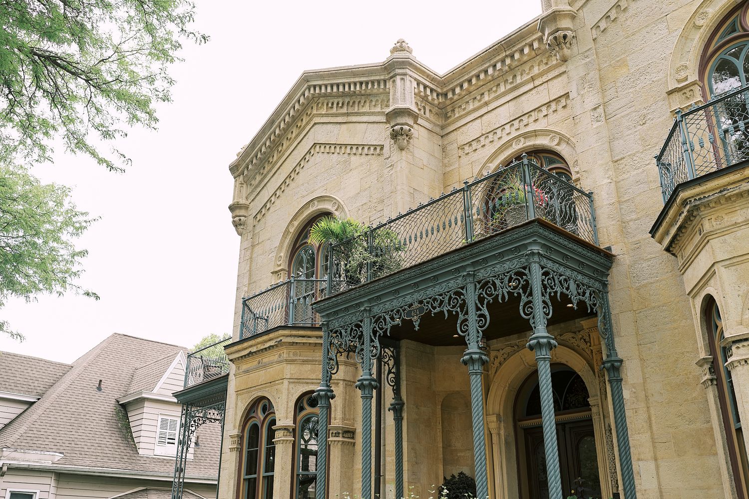 Exterior view of an ornate Victorian-style mansion with detailed architectural features and landscaping.