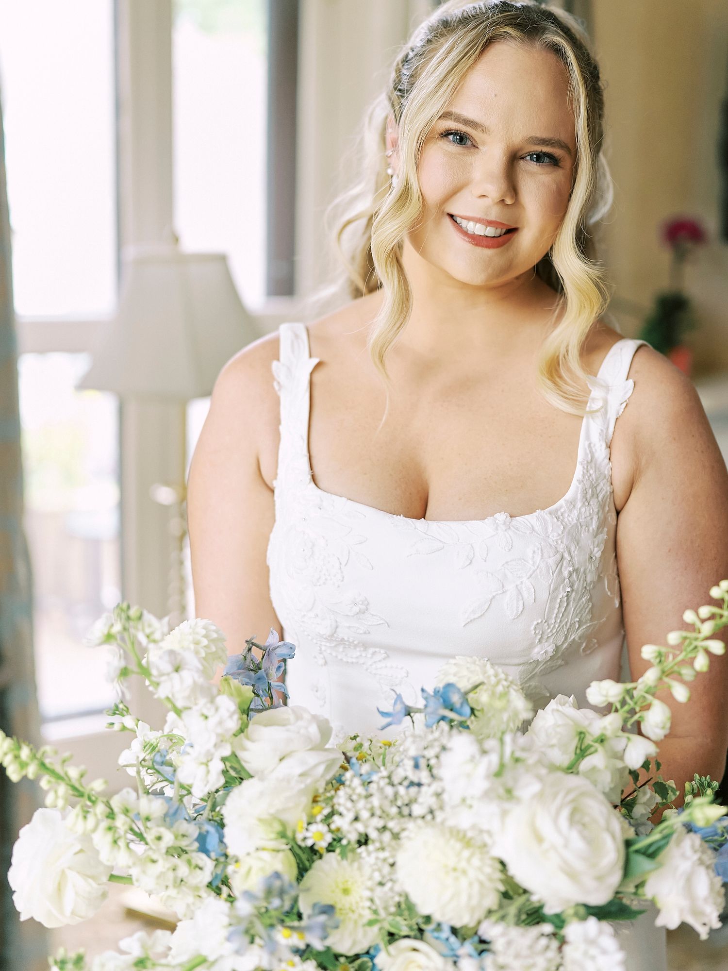 Romantic bridal bouquet featuring white and blue flowers with delicate greenery accents.