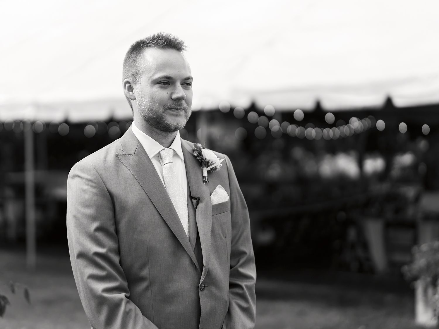 Black and white portraits of someone in formal attire at an outdoor event with string lights in background.