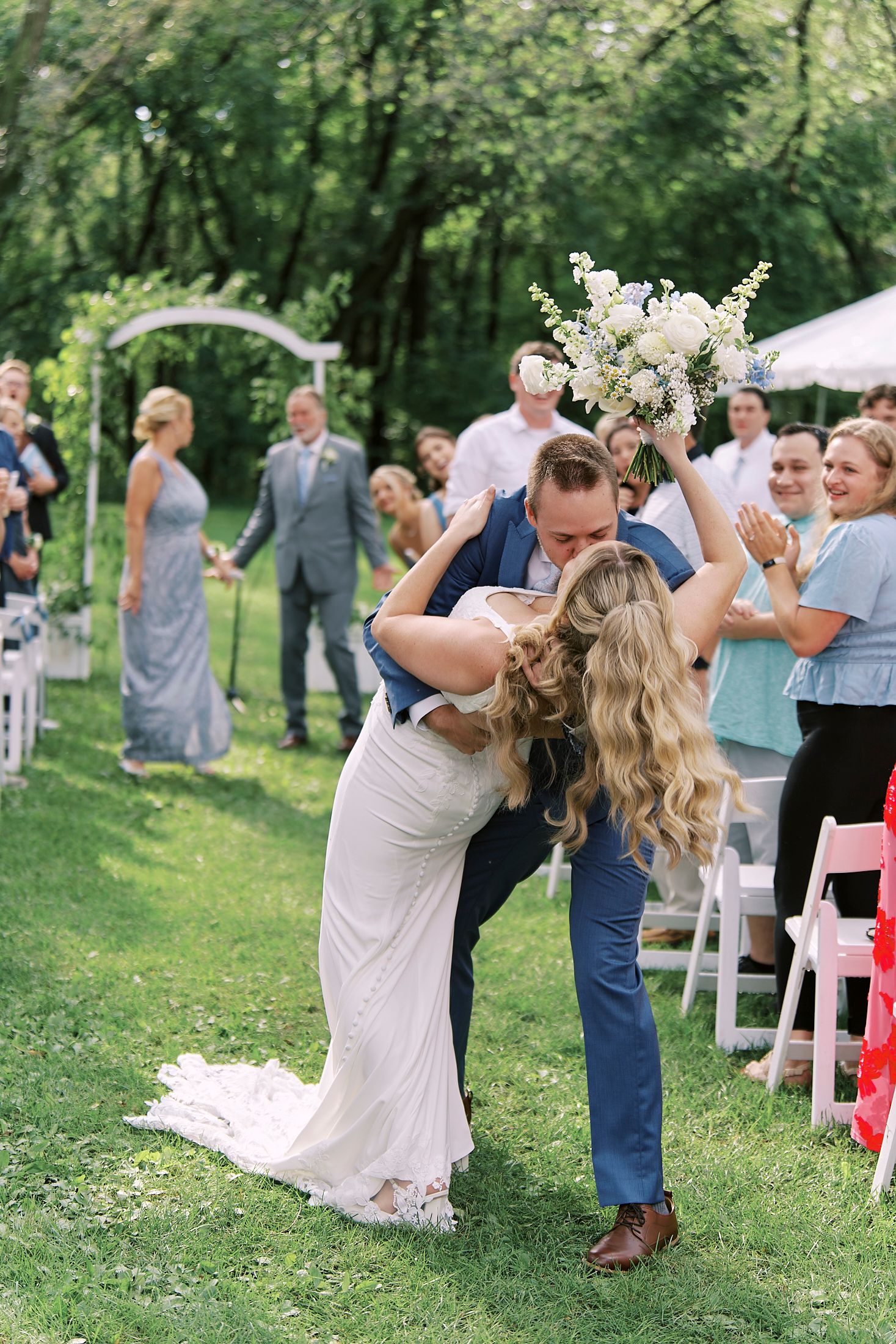 Wedding dance sequence in a lush garden setting with guests watching the joyful celebration.