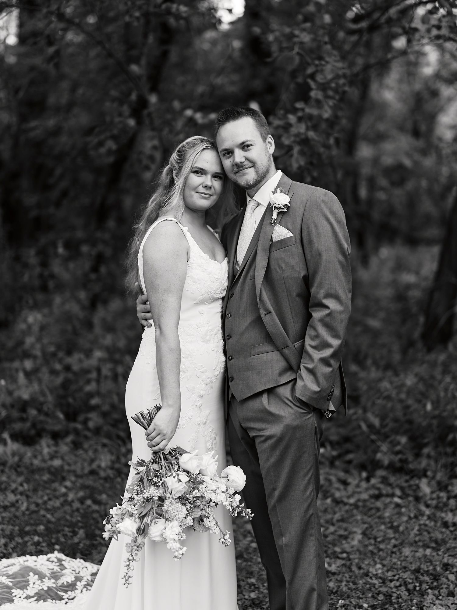 Black and white wedding photos show intimate moments between couple in woodland setting.