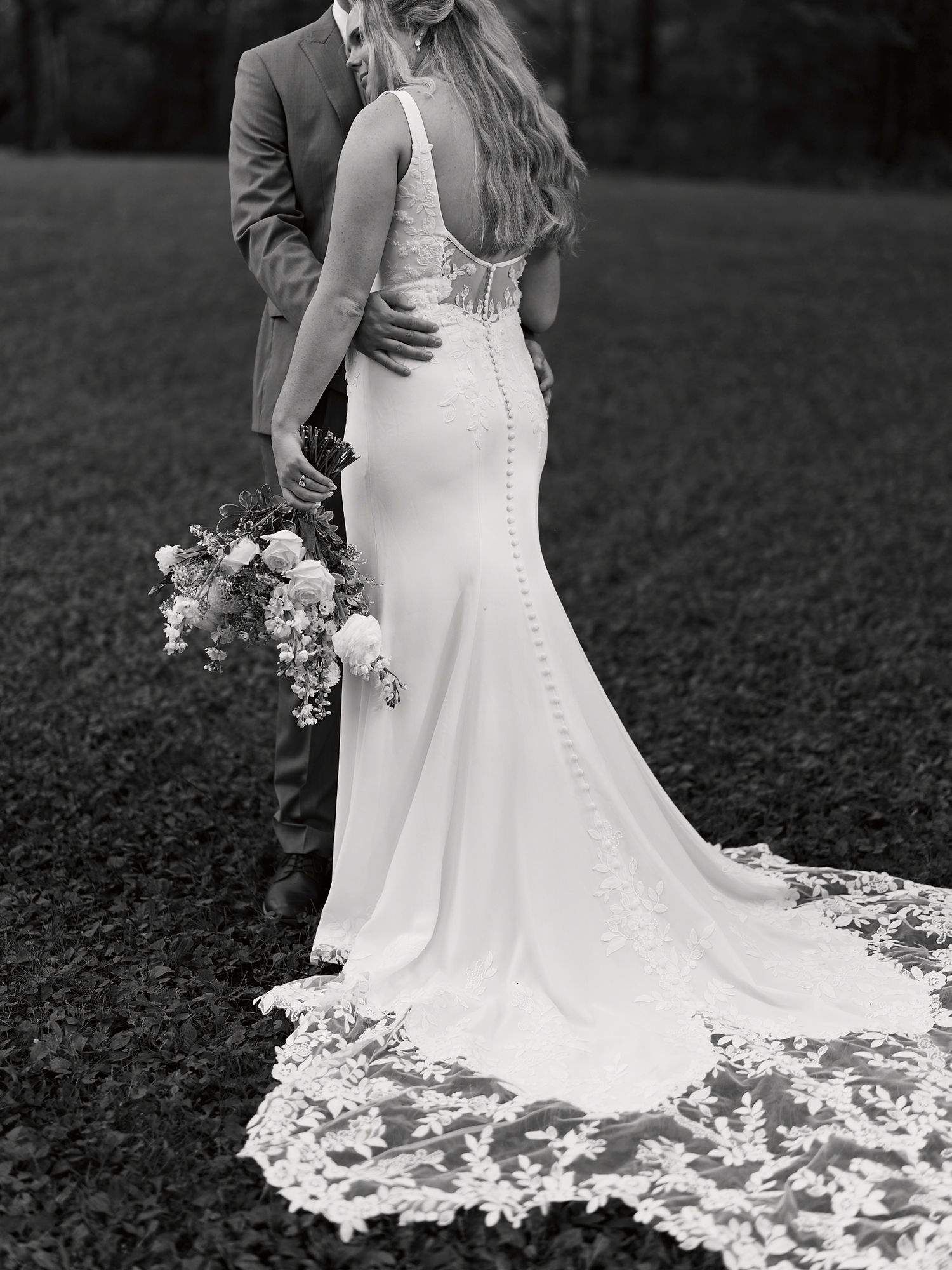 Black and white detail shots of bride's flowing lace wedding dress train.