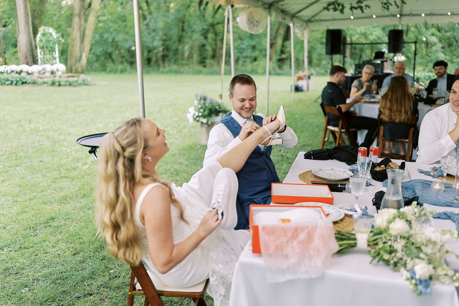 Guests enjoy outdoor dining at casual tables and chairs set up on green grass for a summer gathering.