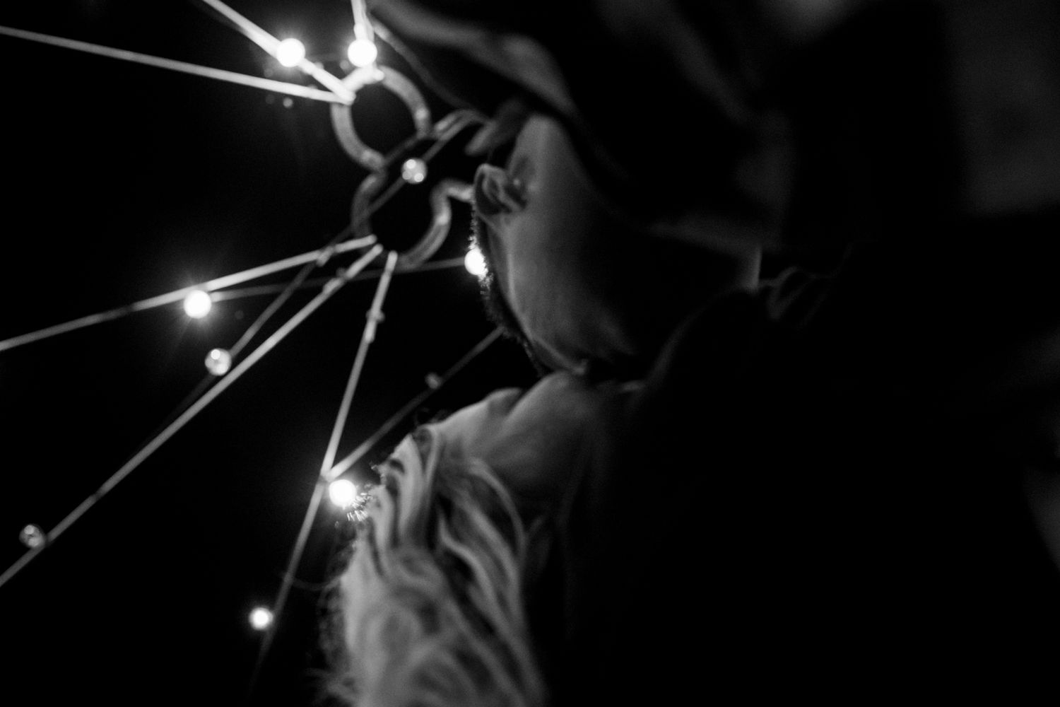Black and white shot of explosive sparks and light beams emanating in darkness.