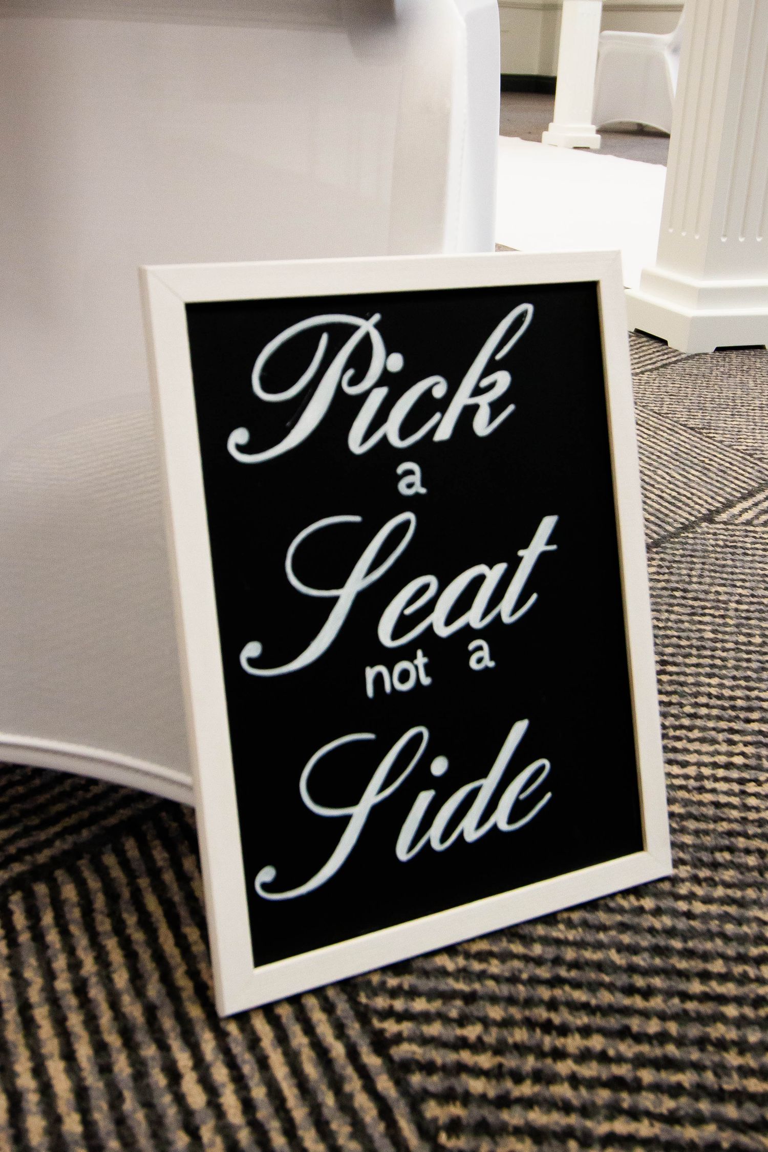 Black and white decorative pick a seat signs on patterned carpet.